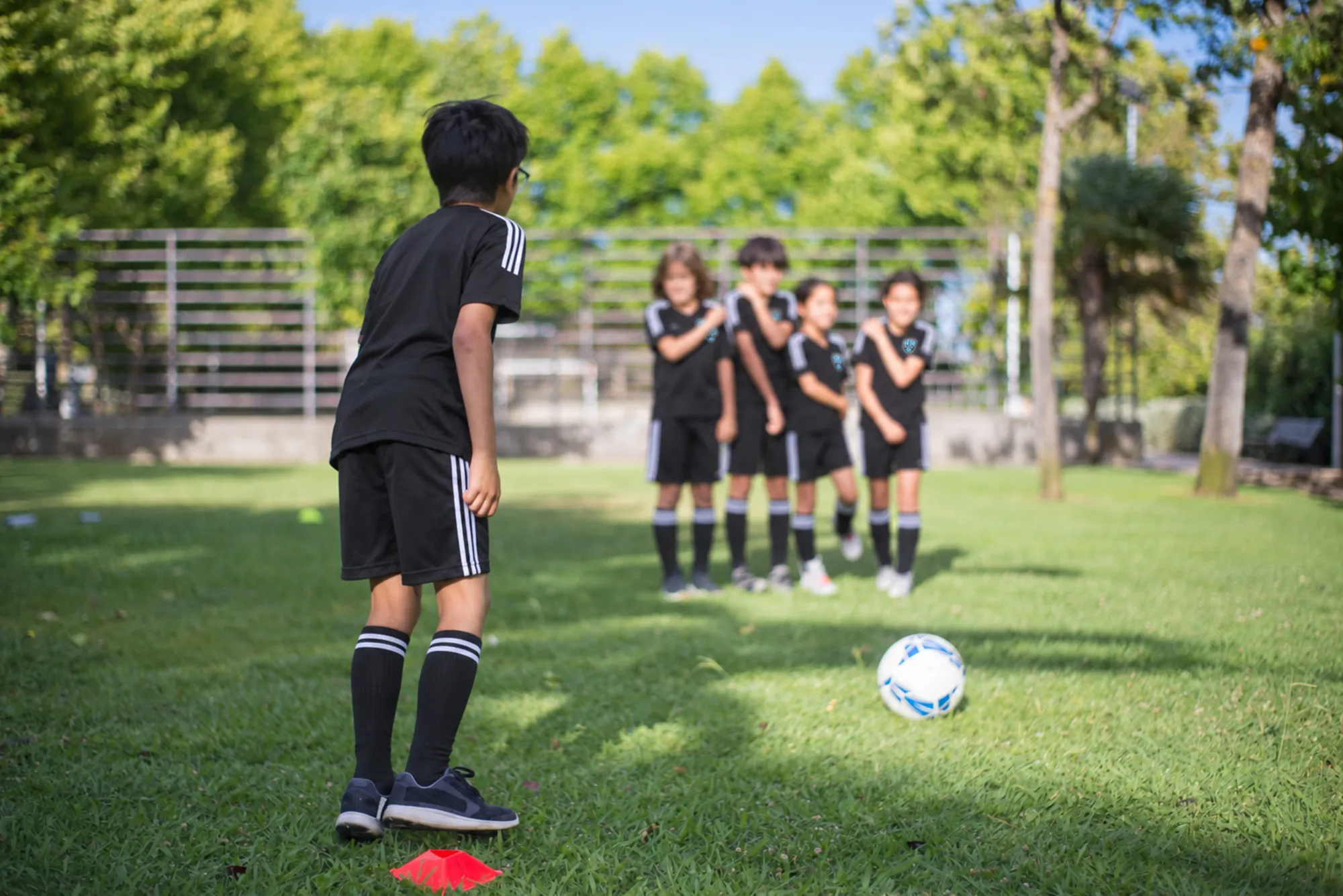 Children playing soccer on the grass